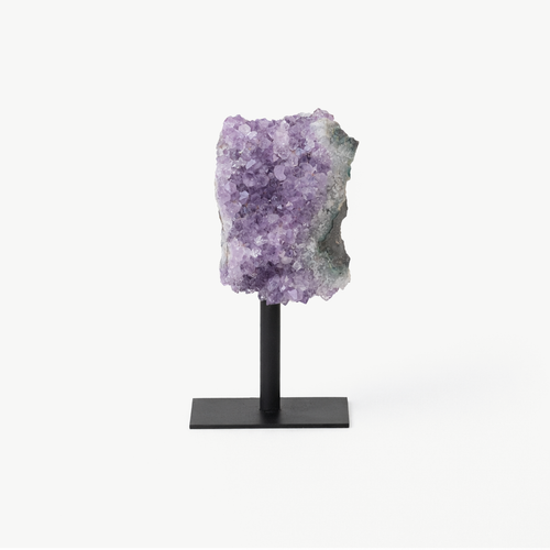 Amethyst geode slab with deep purple crystal points on a black display stand