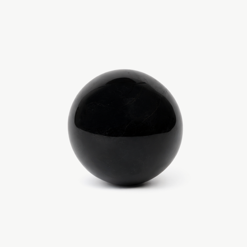 Polished black onyx sphere on a white background