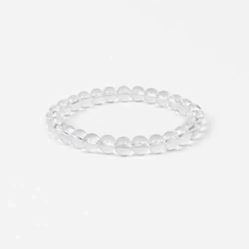Clear Quartz beaded bracelet with polished round clear quartz stones on a stretch cord, on a white background