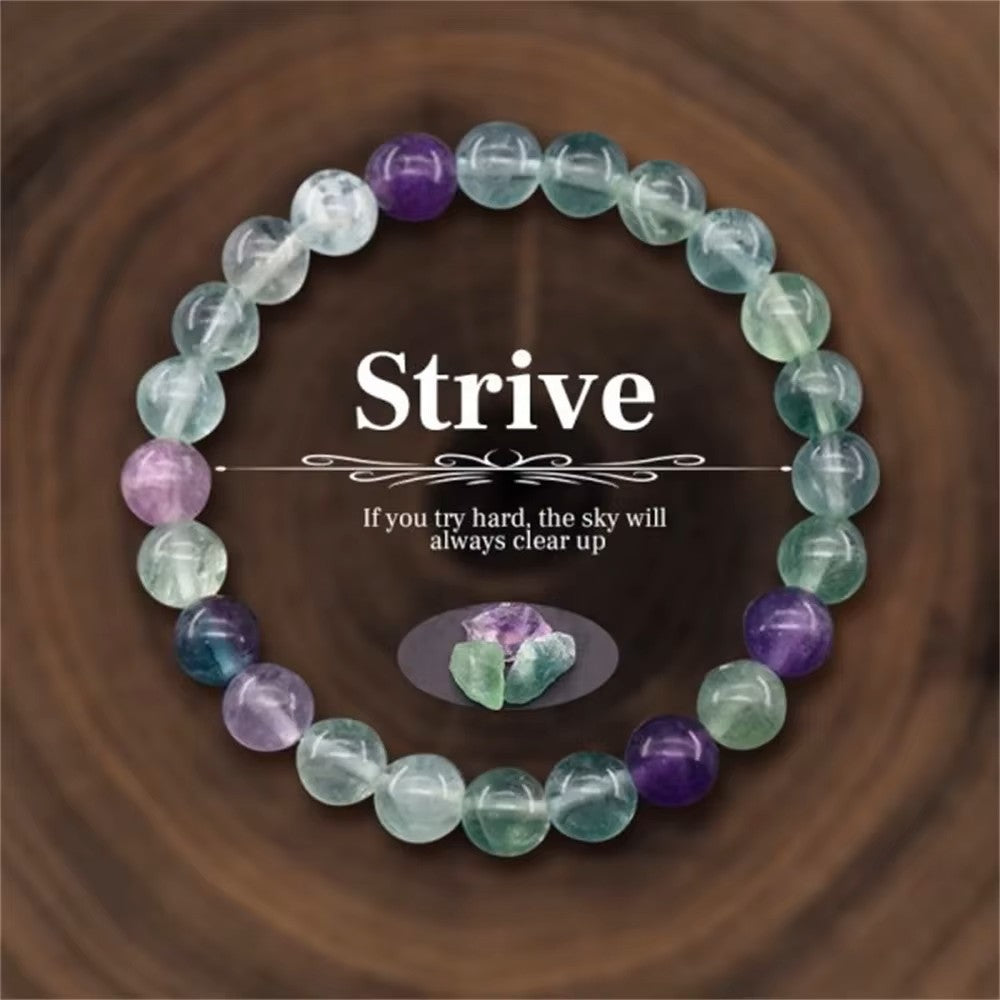 fluorite balance beaded bracelet on a dark wood background with the word strive